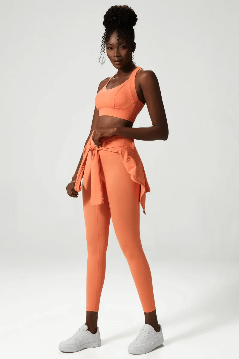 Woman in bright orange versatile yoga and gym activewear set, SF2080, featuring sleeveless bra and leggings. Ideal for all-season fitness.